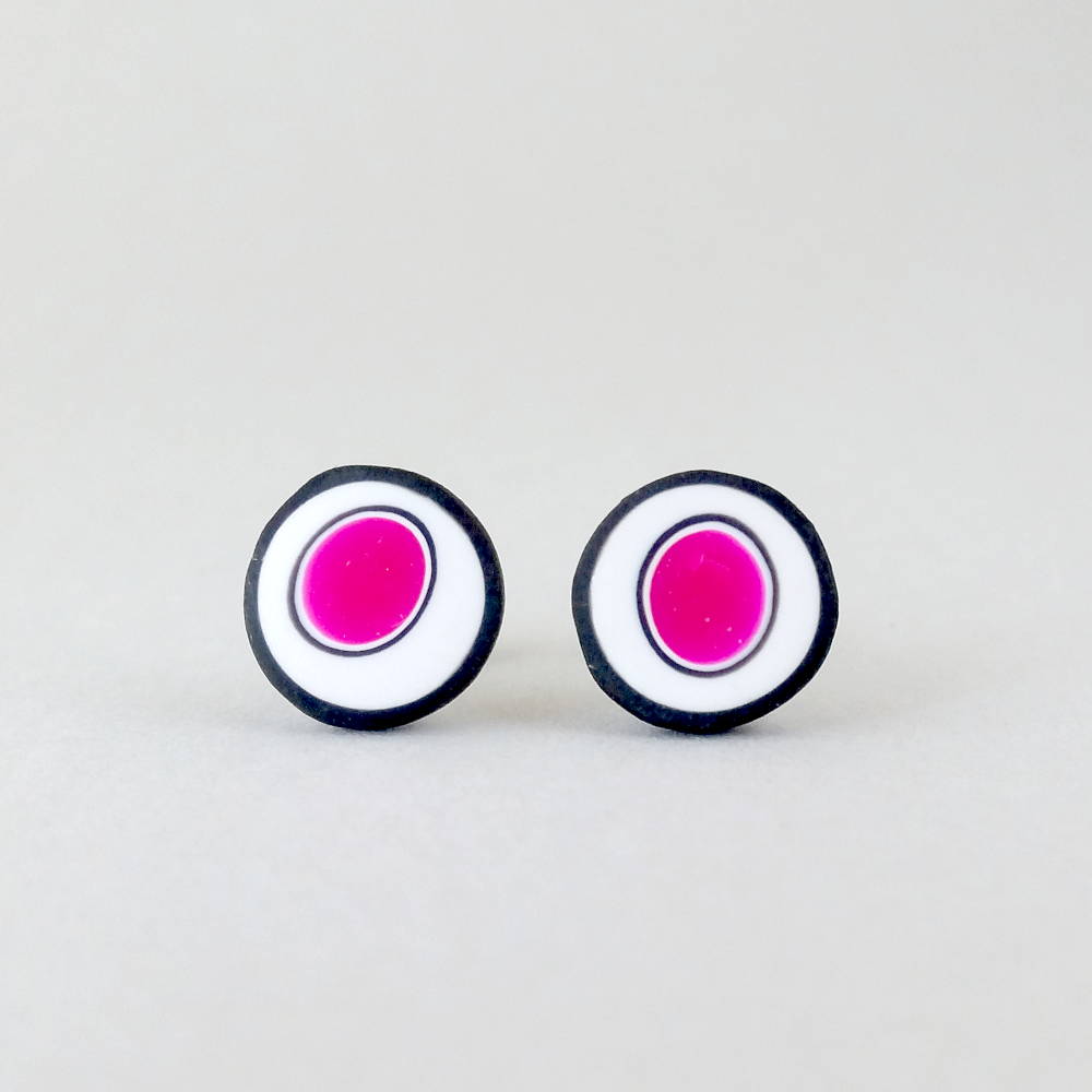 Handmade stud earrings with organic circles of magenta on a white background with a black border.